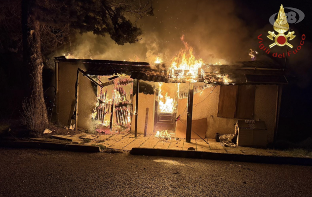 Casa di legno in fiamme, caschi rossi all'opera